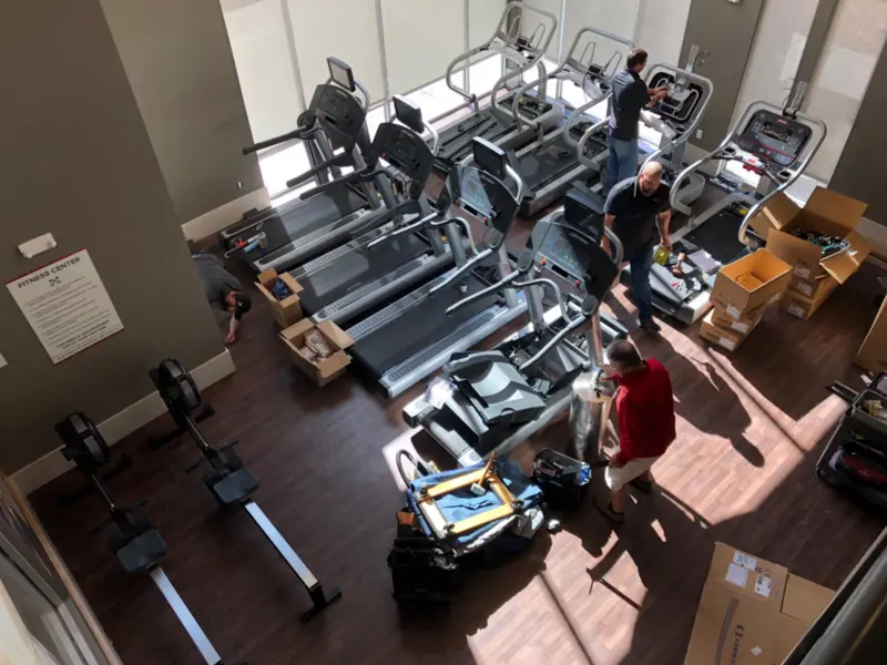 Fitness Repair Xperts team installing treadmills and ellipticals in commercial gym